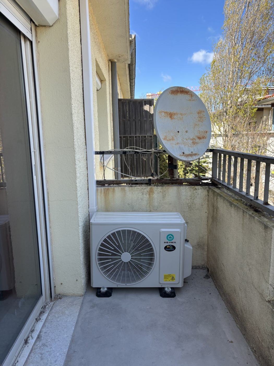 Groupe extérieur de climatisation réversible installé sur un balcon à Canet-en-Roussillon