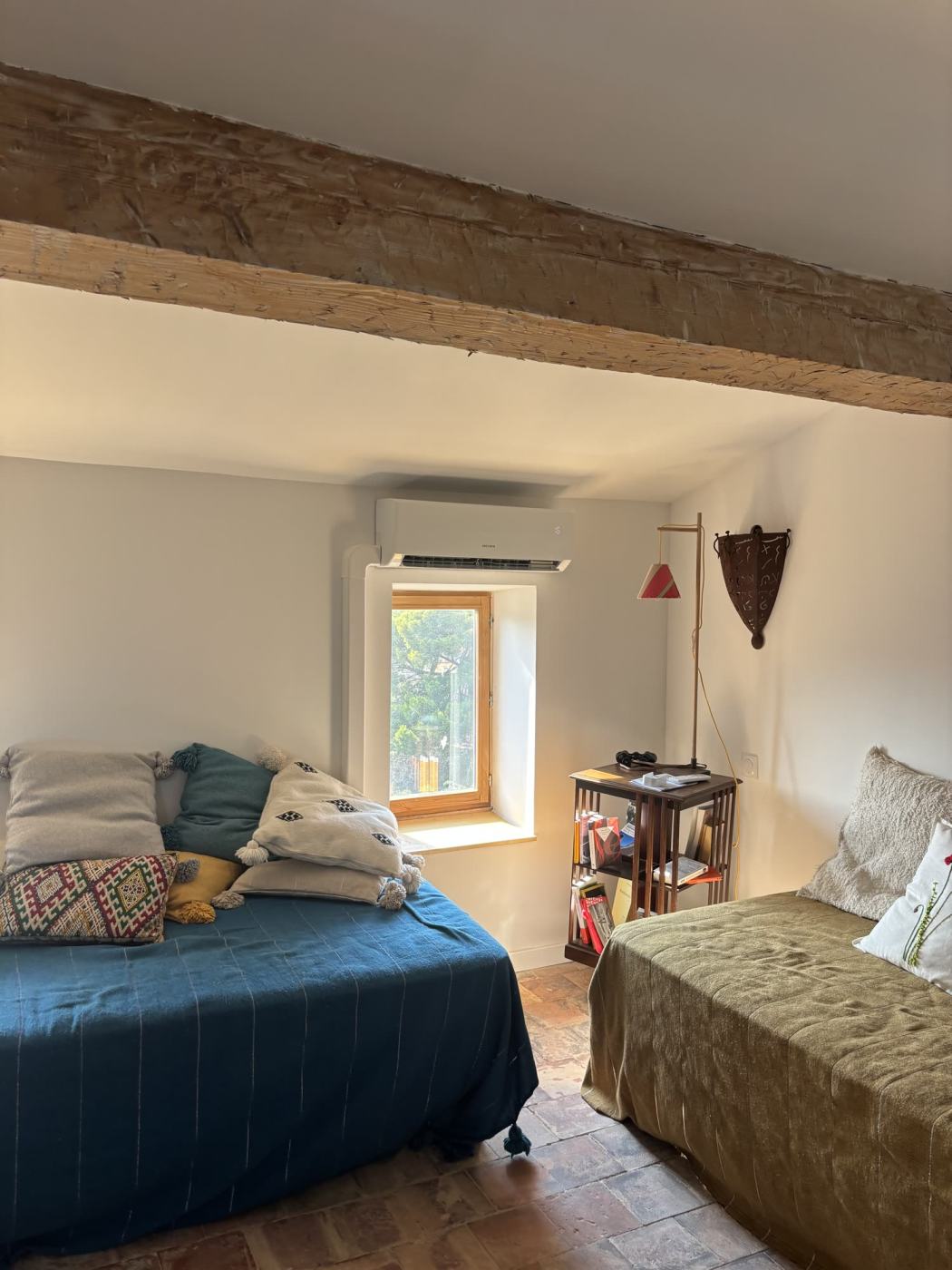 Climatisation murale installée dans une chambre aux poutres apparentes