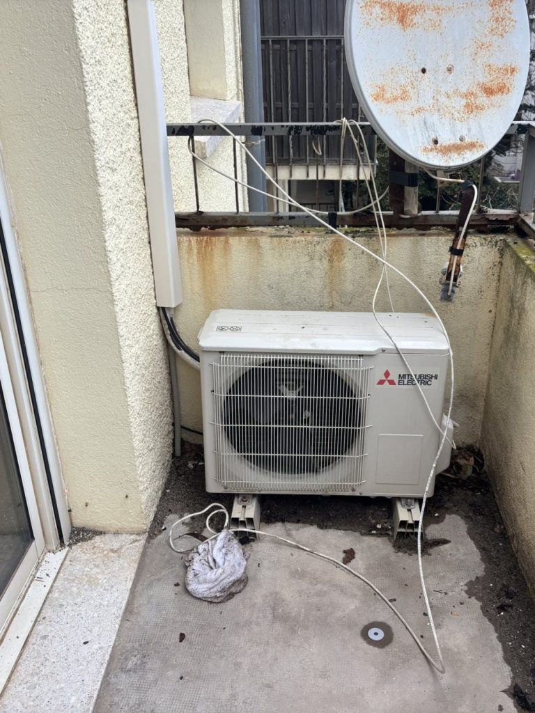 Avant notre passage : l'ancien groupe extérieur, câbles à l'air sur le balcon